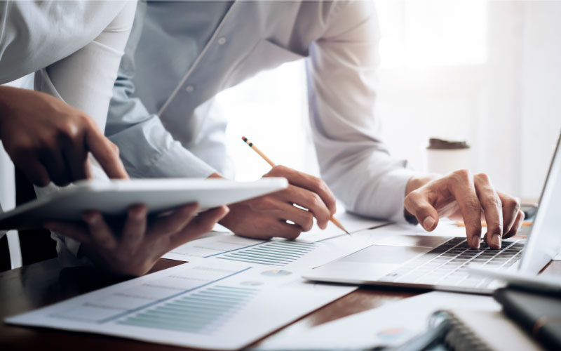 Image of businesspeople standing over a desk